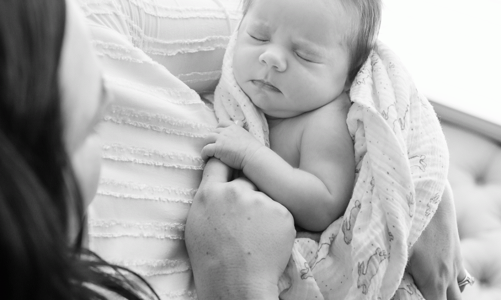 newborn baby cuddled in mom's arms