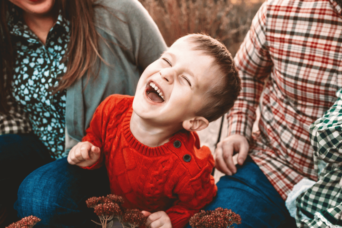 boy sitting between his parents laughing